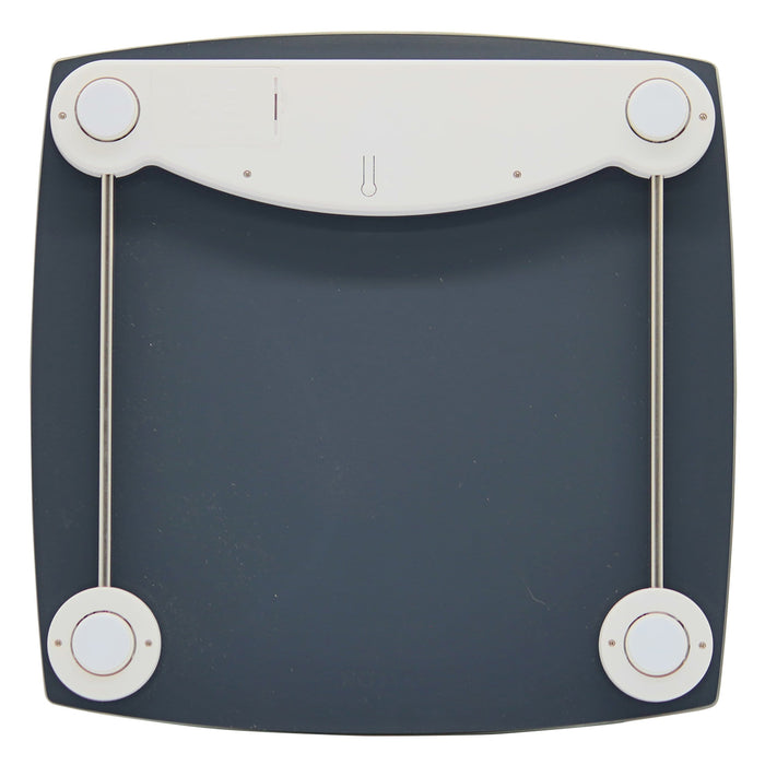 Bottom view of digital scale showing four white circular feet on a curved dark base